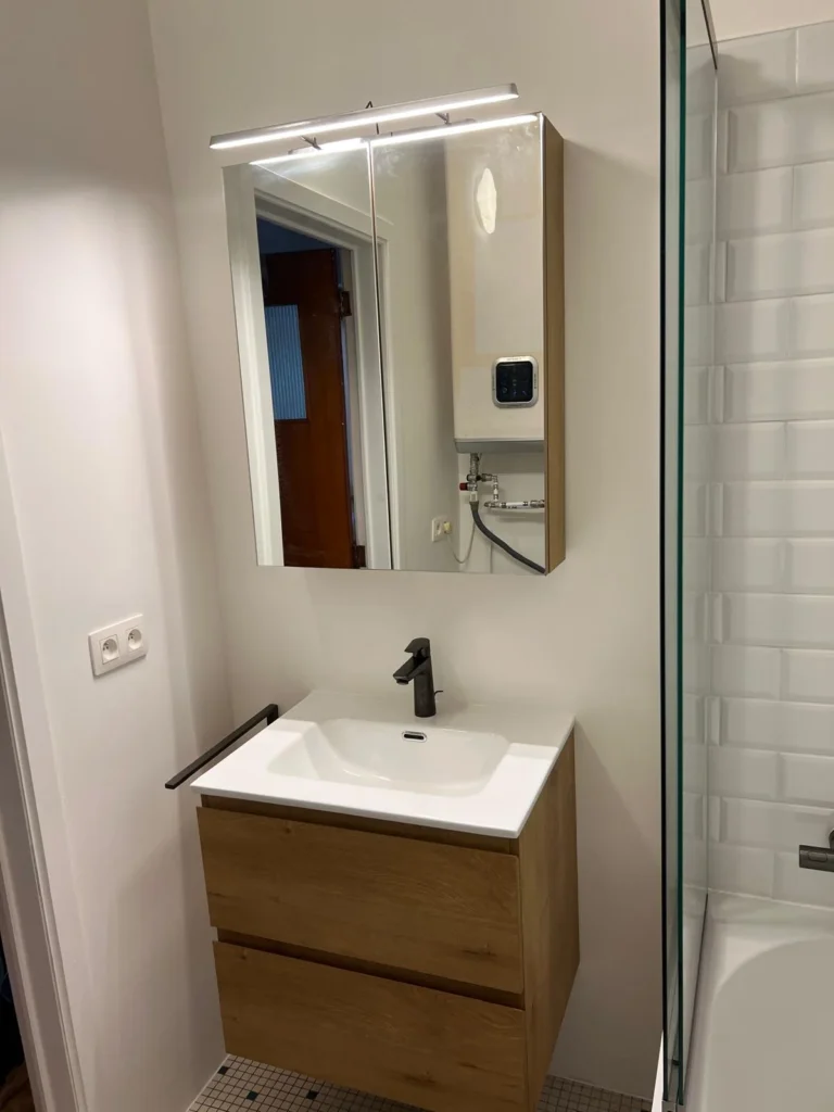Meuble vasque suspendu finition bois avec deux tiroirs, robinet foncé et armoire de toilette à miroir.