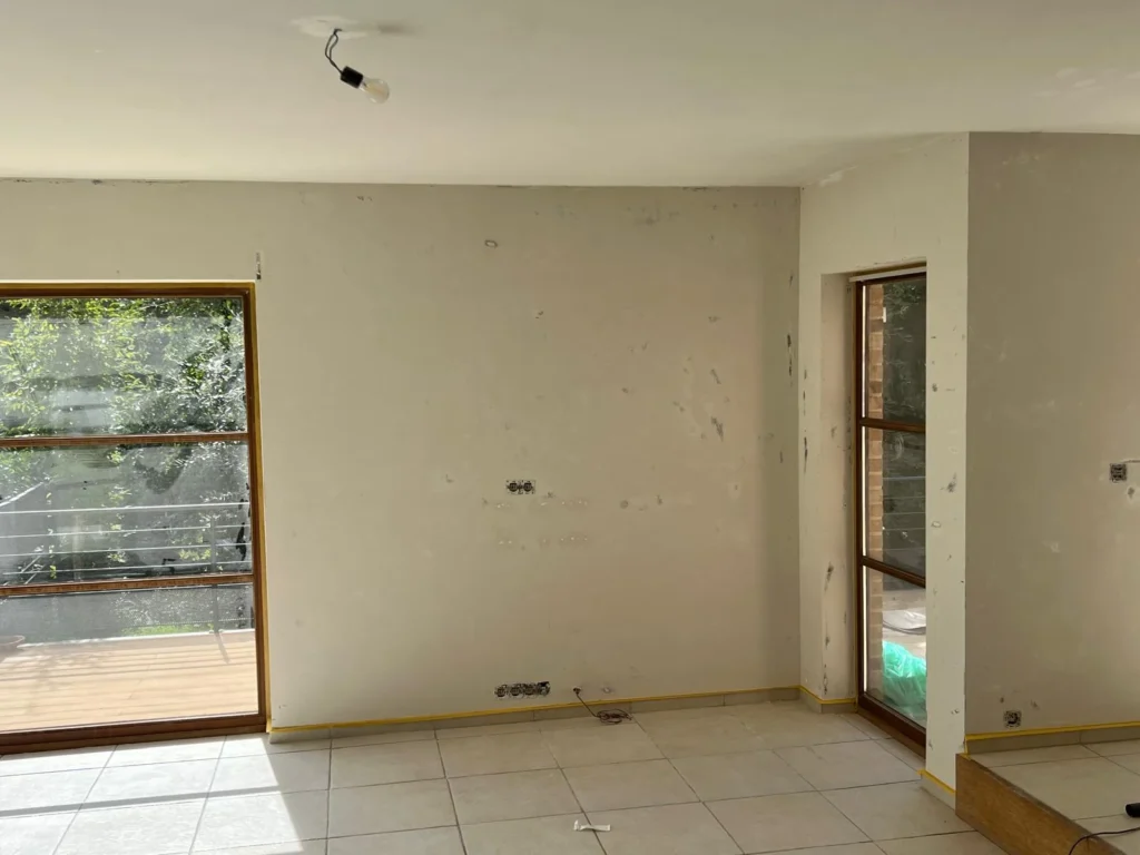Mur présentant des reprises ponctuelles entre deux ouvertures vitrées, avant mise en peinture.