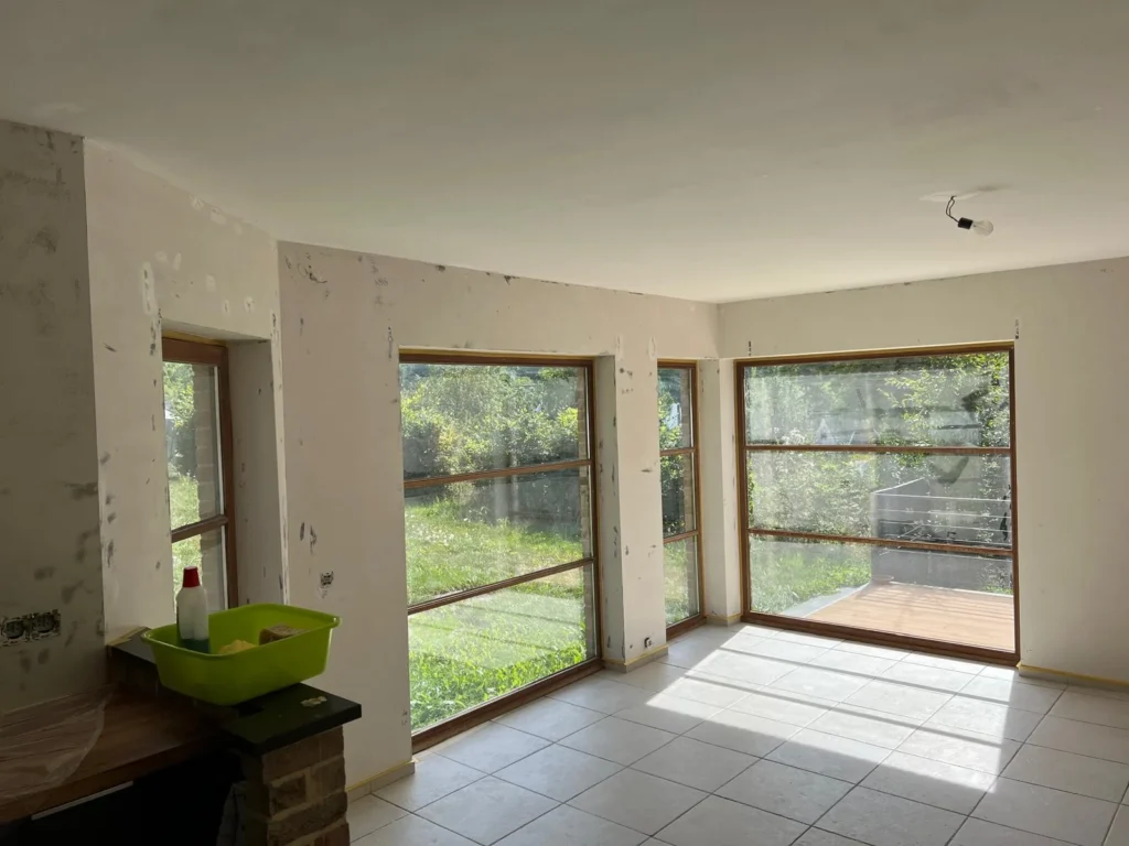 Reprises ponctuelles visibles sur les murs et autour des grandes baies vitrées à châssis bois.