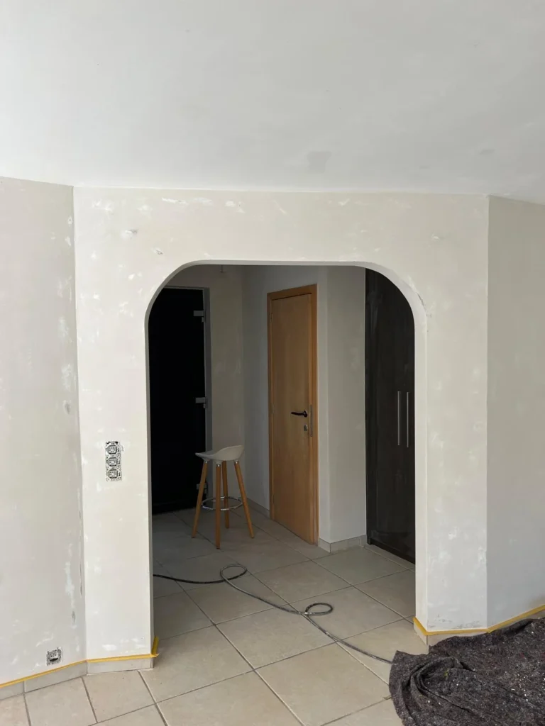 Reprises d’enduit autour d’un passage arrondi et au raccord entre le mur et le plafond.